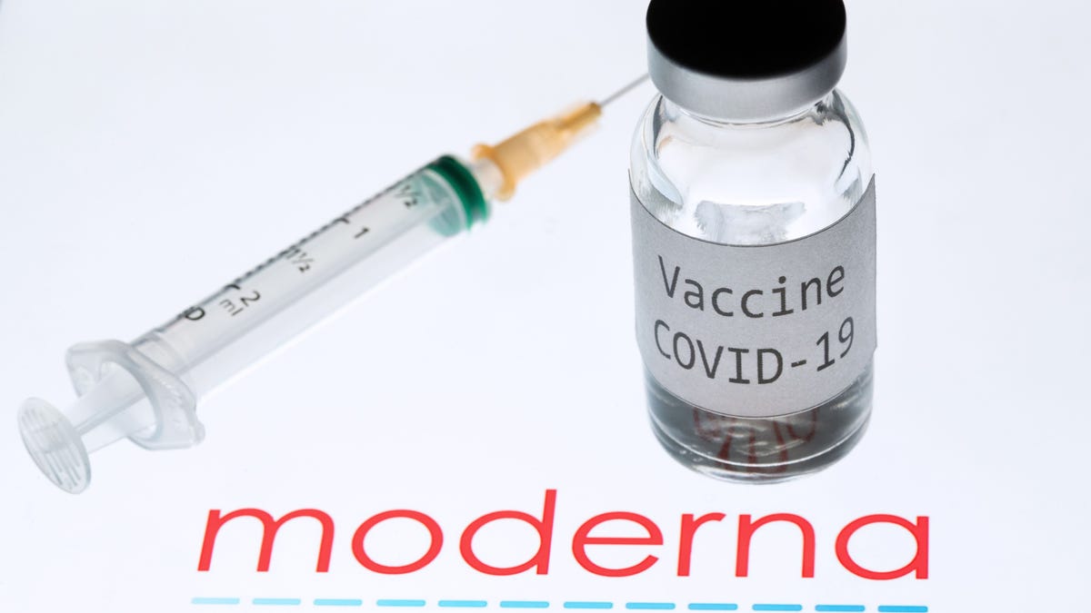 This file photo taken on November 18, 2020 shows a syringe and a bottle reading "Vaccine Covid-19" next to the Moderna biotech company logo.