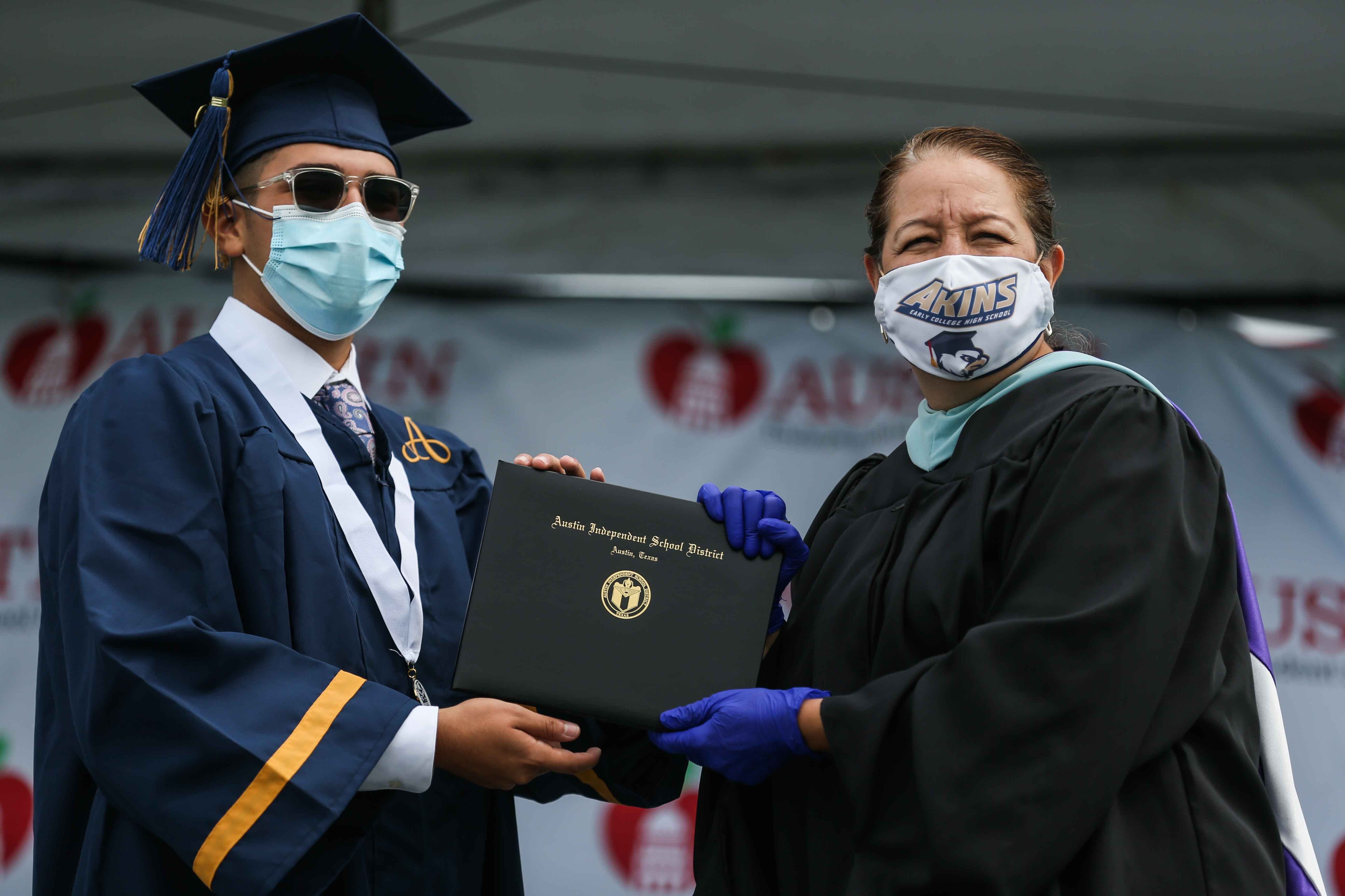 Jorge Garzas Jr. receives his diploma from Principal Tina Salazar at the Toney Burger Center during the graduation ceremony by Akins High School in Austin on Tuesday, June 23, 2020.