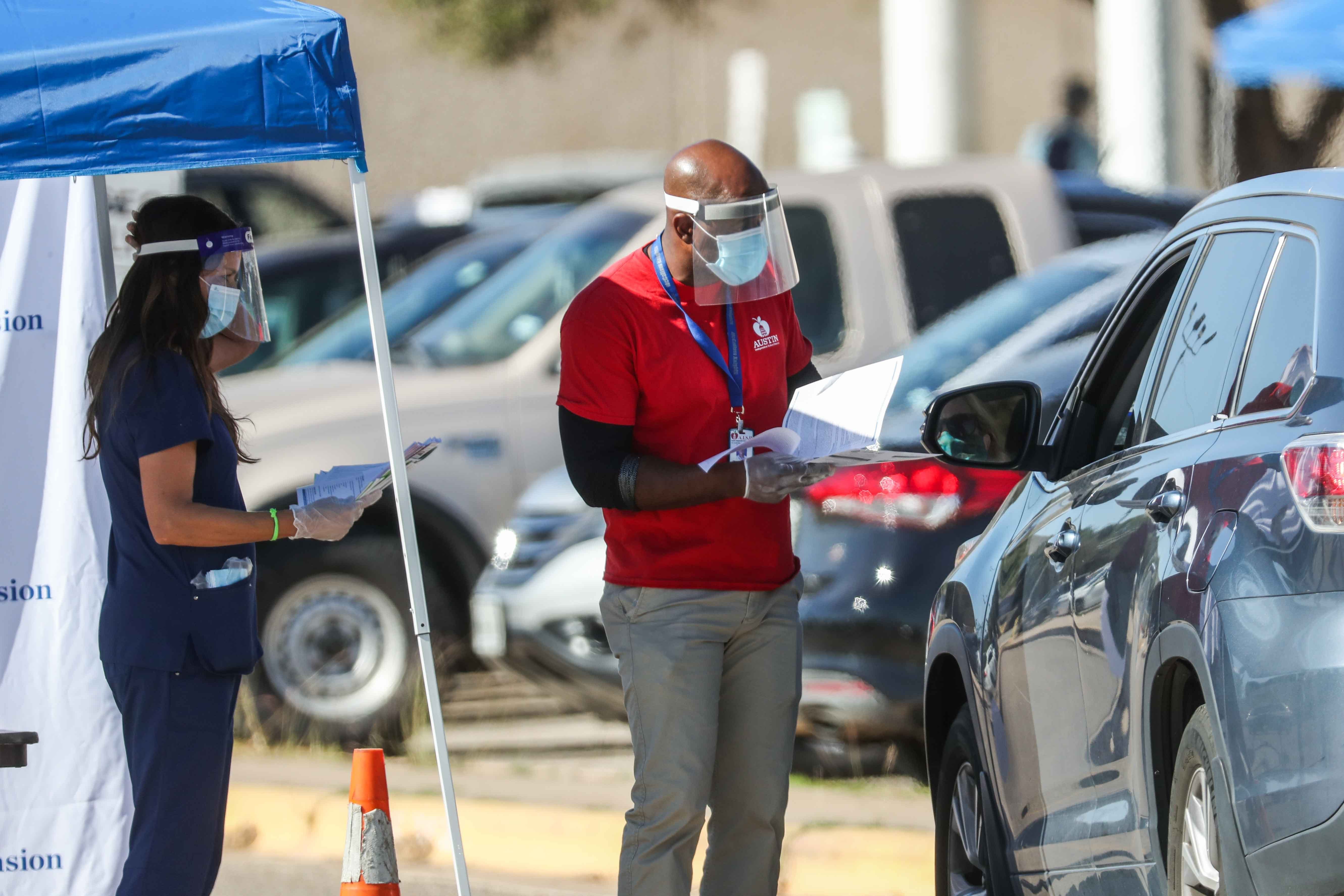 Austin Independent School District staff instruct an attendant where to go to take a COVID-19 tests for staff and students who attend in person classes at the Austin High School after the outbreak in cases at this site in Austin, on Monday, November 16, 2020.
