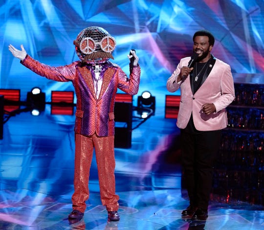 Disco Ball, left, and host Craig Robinson appear during an episode of Fox's "The Masked Dancer."
