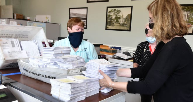 Barnstable Town Clerk Ann Quirk, left, pictured here with bundles of applications for mail-in ballots, said she would welcome mail-in voting in future elections given its success in bringing more people out to the polls.