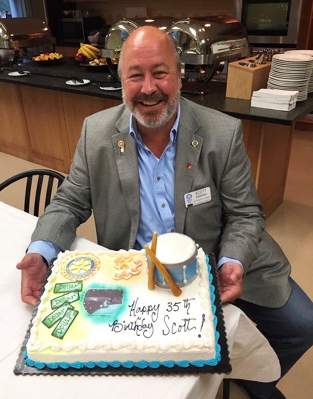 Robert "Scott" Darrah cracks a smile at a Rotary Club event while posing with a birthday cake presented in his honor. The longtime Rotarian died in early November at age 57 as a result of COVID-19 complications.
