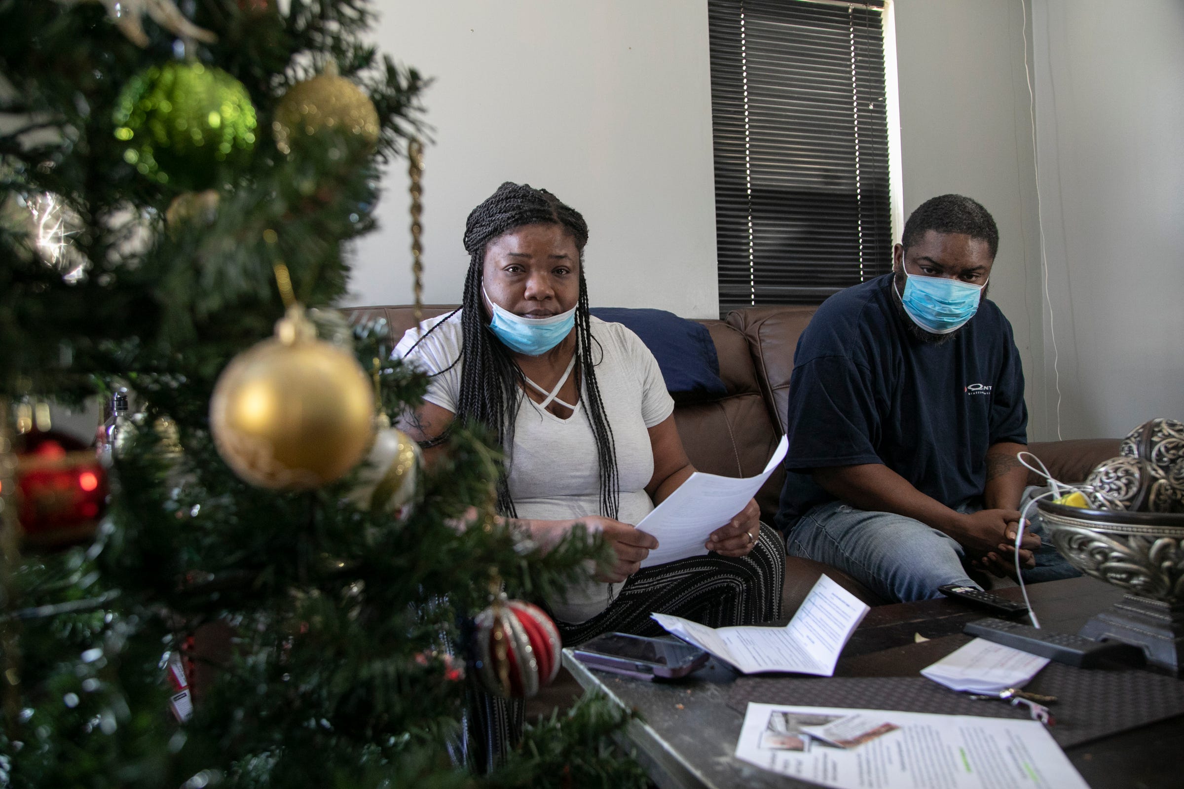 Sharesa Washington, 37, left, and her husband Jimmy Washington, 39, look over eviction paperwork in their Detroit home Friday, Dec. 18, 2020.