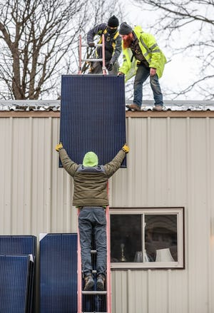 Representatives from GRNE Solar, Branch Manager Kendall Ludwig, top left, and Installer Mike Dunn, right, and Tim Kehoe, below, install solar panels at a rural property in Lebanon Ind., Monday, Dec. 21, 2020.