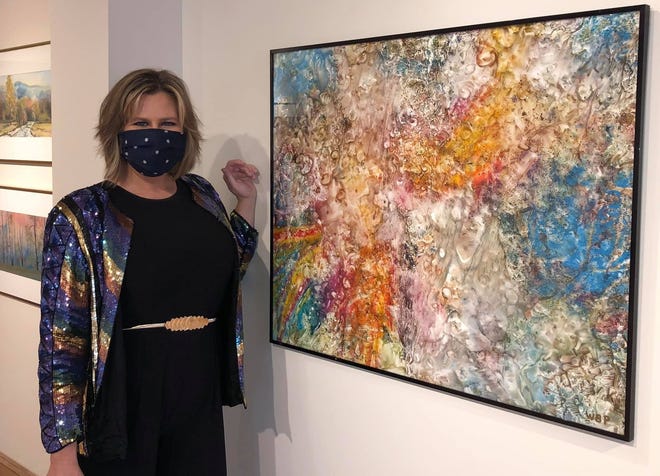 Perkinson Center Executive Director Marly Fuller stands by one of Baxter Perkinson's pieces featured in the Baxter & Elaine Perkinson Gallery show in Chester called "Home" on Dec. 12, 2020.