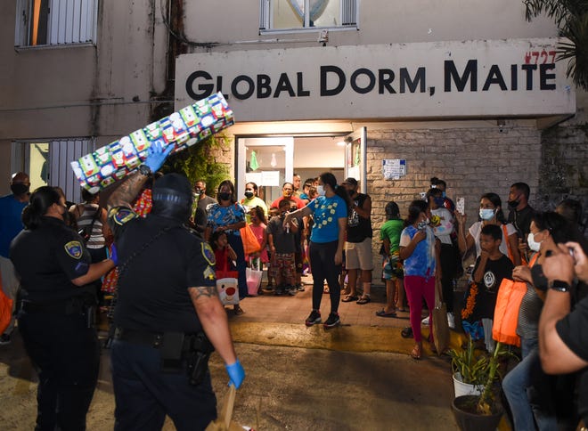 Families residing at the Global Dorm Maite homeless shelter receive treats and presents during a gift drive by the Guam Police Department in Maite in this Dec. 22, 2020, file photo.