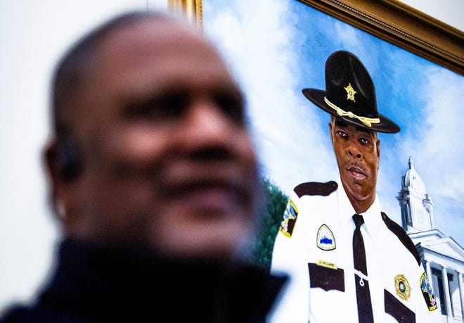 Lowndes County Sheriff Christopher West, foreground, reminisces about slain Lowndes County Sheriff Big John Williams, a year after Williams' death, as he stands near a portrait of Williams at the county courthouse in Hayneville, Alabama, on Nov. 12, 2020.