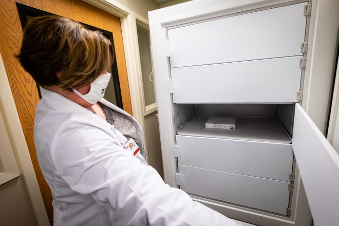 Lake Huron Medical Center pharmacy director Tricia Millbrand opens the ultra-cold freezer where they store the COVID-19 vaccine Tuesday, Dec. 22, 2020. The hospital received 975 doses of the vaccine.