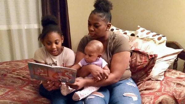 Larhonda Stewart reads to her two children, Zorah 