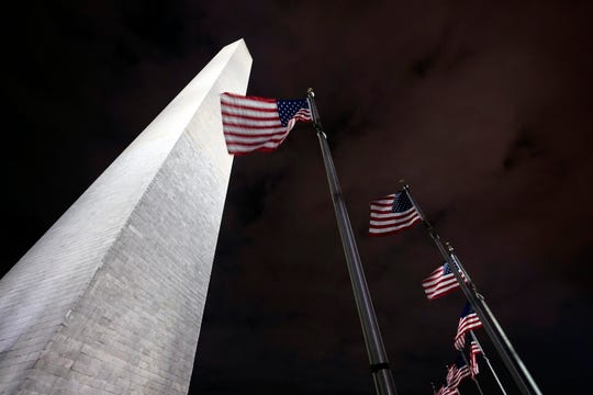 American flags fly around the Washington Monument, which was temporarily closed last week because of a recent visit by Interior Secretary David Bernhardt, who tested positive for the coronavirus on Wednesday, shortly after conducting a private tour of the monument.