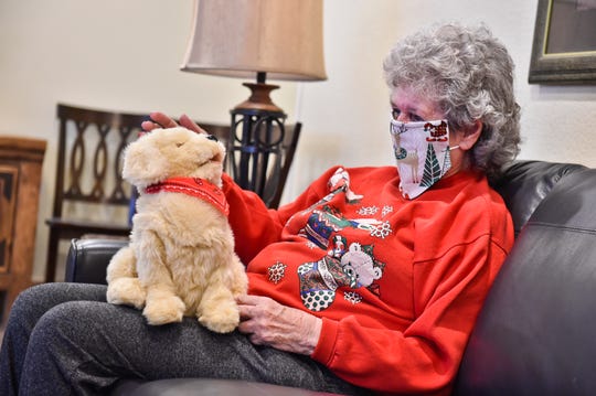 Margie Copenhaver, an 83-year-old resident of Eagle Manor in Helena, Mont., pets her robotic pet dog Muffie. “Muffie is good company,” says Copenhaver. “Muffie talks to me and I talk to her. She is a cutie.” The Helena Area Agency on Aging says money for the pets came through federal virus relief funding.
