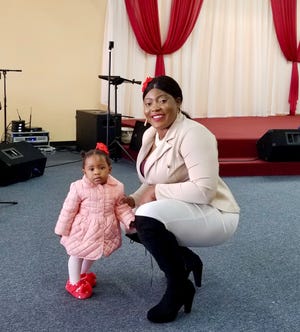Divinelove Ogini and her daughter Lily attend a church service in Houston. Their family has relied on donations of clothes and food from the congregation during the pandemic.