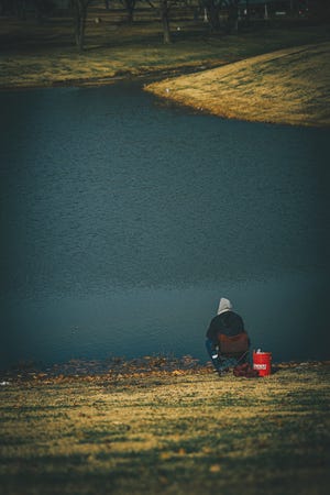 A fisherman patiently waits for a fish to cooperate at Bartlesville's Sooner Lake.