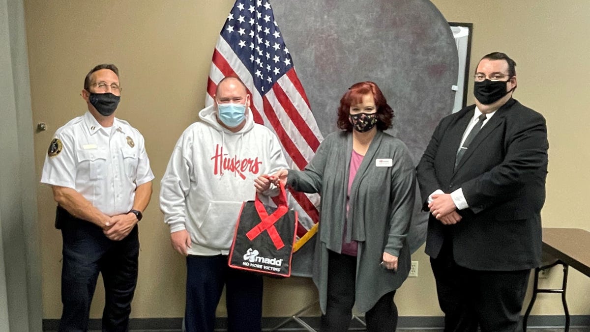 Dodge City police Capt. Shannon McGee; Susan Ratzlaff, MADD; and James Crux, assistant Ford County attorney, present police Sgt. Thad Brown special recognition for the Holiday Drive for Victims, remembering those killed or injured by drunk driving.