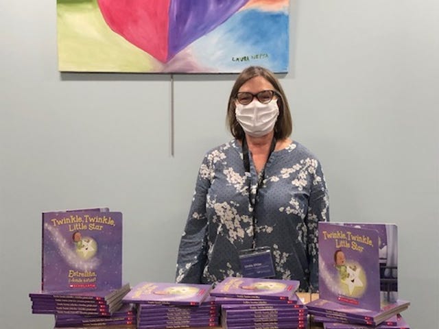 Tuscarawas County Public Library children’s services manager Linda Uhler with the books purchased through the Books for Babies Trust Fund.
