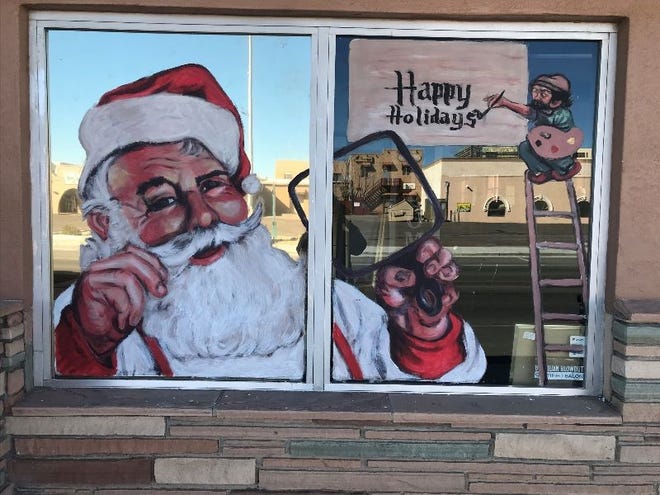 Artist Lorenzo Zapada’s depiction of Santa Claus holding a mirror adorns the window at the LUX salon in downtown Las Cruces. It is this year’s first-place co-winner in the city’s Ventanas Vivas event.
