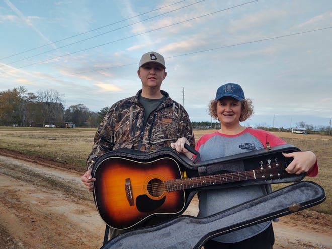 Jake Perry and his mother Amanda hold the guitar and case Jake found on the side of the road in south Georgia on Dec. 19. They are looking for the owner whom they believe may have ties to St. Augustine.