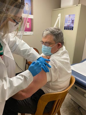 Tammy Smith, the Director of Nursing at the Coshocton Country Health Department, administers Dr. Douglas Virostko with his first dose of the Covid-19 vaccine on Dec. 23.