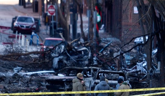 Investigators walk through the scene of the explosion on Second Avenue on Friday, Dec. 25, 2020 in Nashville, Tenn.