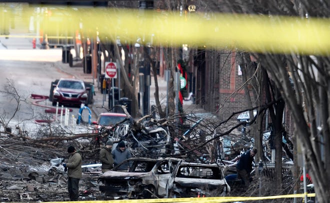 Investigators walk through the scene of the explosion on Second Avenue on Friday, Dec. 25, 2020 in Nashville, Tenn.