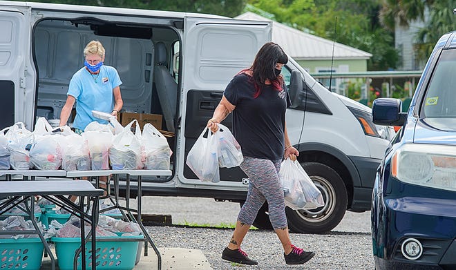 Pie in the Sky volunteer Rosalie Cocci takes bags of food to the car of a volunteer who will distribute it to elderly people in need in St. Johns County on Wednesday, June 17, 2020.