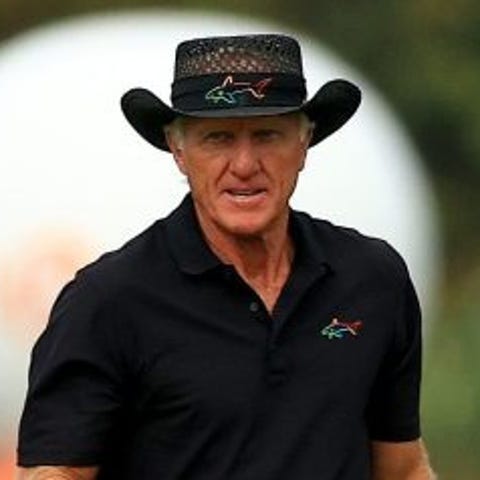 Greg Norman and son Greg Norman Jr. walk up the 18