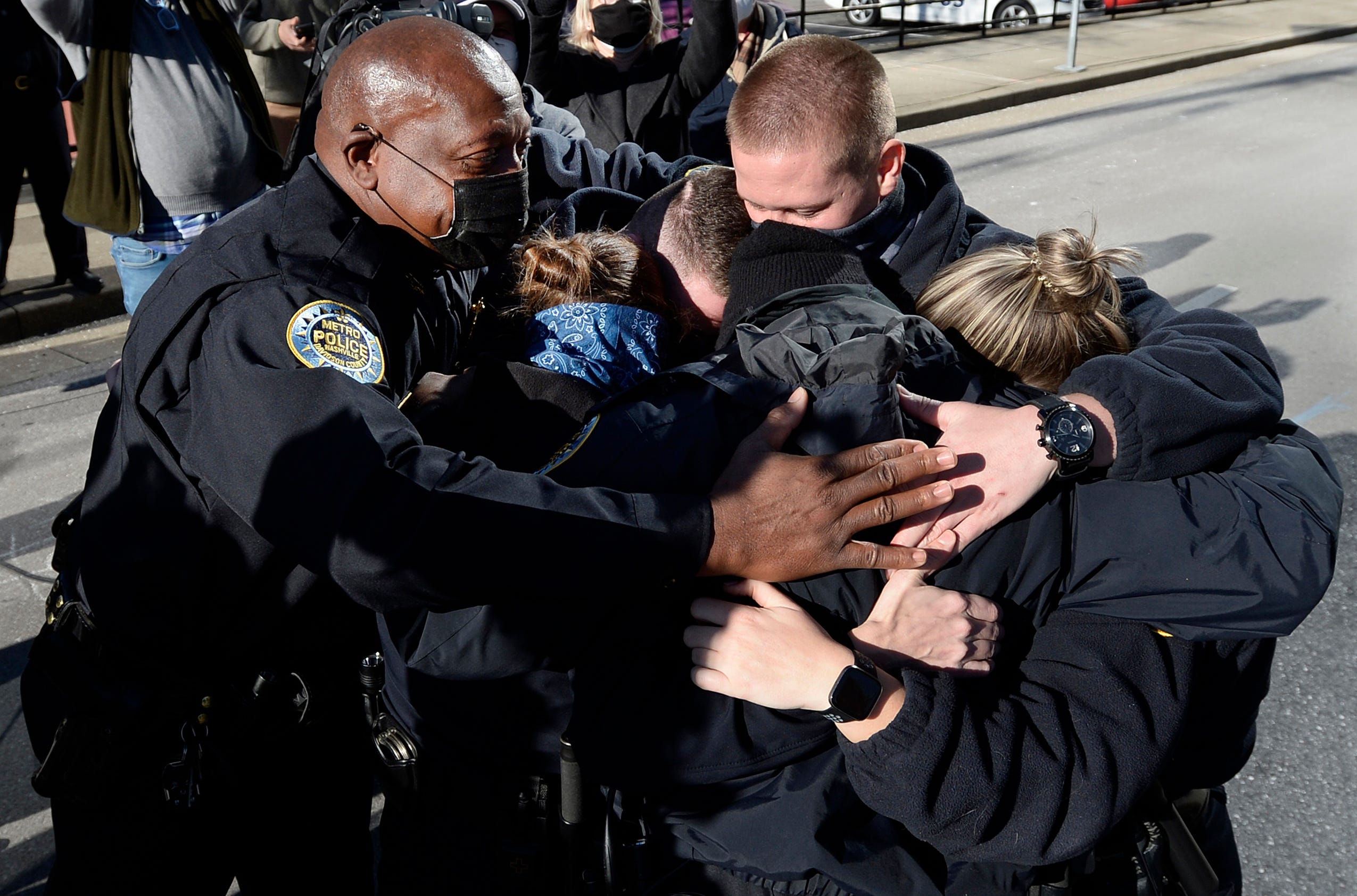 Nashville Metro Police Chief John Drake, left, and officers Amanda Topping, Michael Sipos, Tylor Luellen, Brenna Hosey, and James Wells spend a moment in a group hug after the press conference on Sunday, December 27, 2020 in Nashville, Tenn.