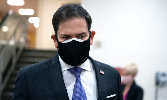 Sen. Marco Rubio, R-Fla., wears a protective mask while walking in the U.S. Capitol in Washington, Dec. 11, 2020.