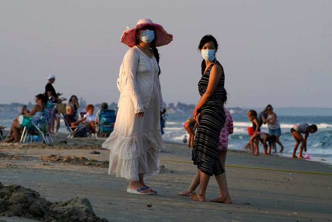 Women wear masks Aug. 11, 2020 to help prevent the spread of coronavirus at the end of a beach day in Ogunquit, Maine. The virus, which killed more than 230 in Maine and crippled the state's economy, was voted unanimous top story of 2020 in Maine by The Associated Press.