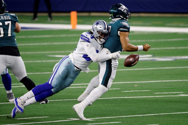 Philadelphia Eagles quarterback Jalen Hurts (2) fumbles the ball as he's sacked by Dallas Cowboys defensive end Randy Gregory (94) in the second half of an NFL football game in Arlington, Texas, Sunday, Dec. 27. 2020. The Eagles recovered the fumble. (AP Photo/Ron Jenkins)