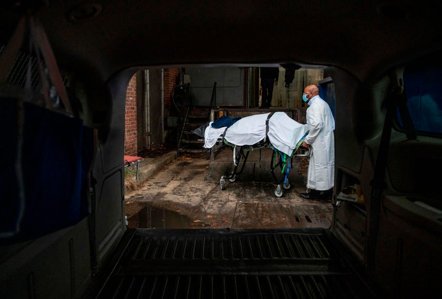 Maryland Cremation Services transporter Reggie Elliott brings the remains of a COVID-19 victim to his van from the hospital's morgue in Baltimore, Md. on Dec. 24, 2020 during the COVID-19 pandemic.