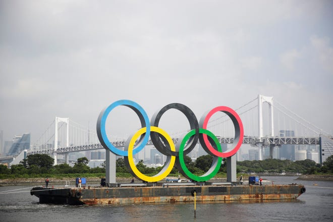 In this Aug. 6 file photo, the Olympic rings for the Olympic and Paralympic Games Tokyo 2020 pass by on a barge by tugboats off the Odaiba Marine Park in Tokyo. Tokyo Olympic officials said Dec. 24, they have reached a "basic agreement" with all 68 domestic sponsors to extend their contracts into next year to support the postponed Games.