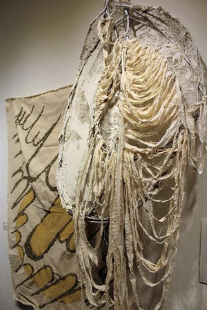 A fiber piece titled "Pranayama #4" imitates the lungs and ribs of the human body. Another Larla Morales piece titled "Golden Age" is to the left. The yellow color is provided by pyrite.