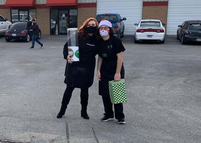 Volunteers Joy Wilson and Kirsten Alunni welcome guests at the drive-thru for the spaghetti dinner fundraiser for Second Harvest Food Bank held at the Cutting Edge Classroom Wednesday, Dec. 23, 2020.
