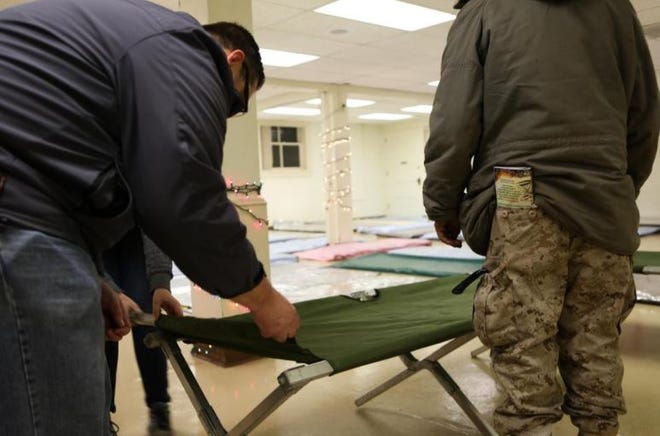 Volunteers set up cots and mats at an Egan Warming Center site.