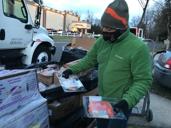 Kenny's World owner Kenny Jackson said Whole Foods and Amazon have provided fresh foods including produce, dairy and fish like the salmon and tilapia he's holding outside his Haddon Heights store.