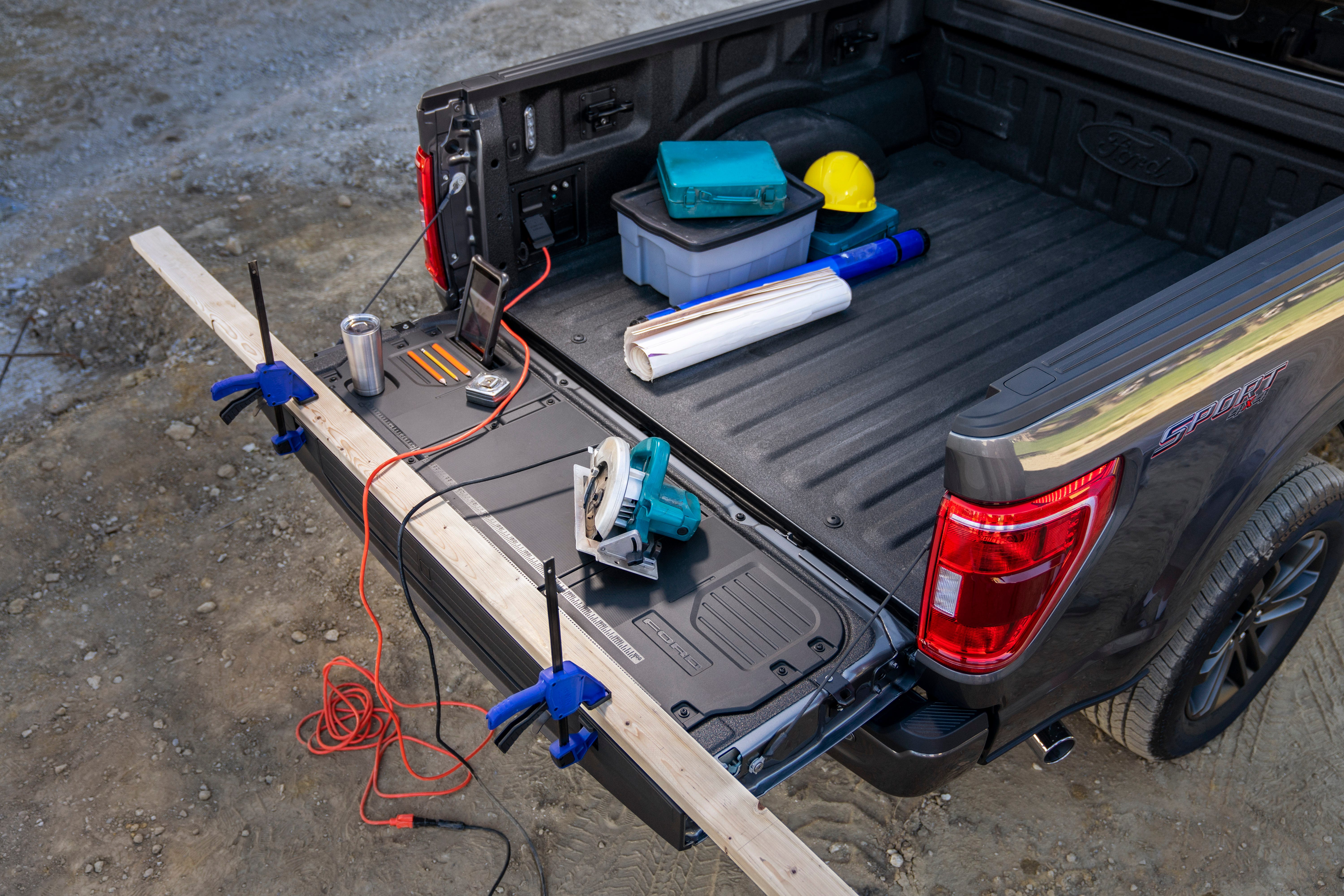 All-new F-150 with available Pro Power Onboard and available Tailgate Work Surface including integrated rulers, a mobile device holder, cupholder and pencil holder.