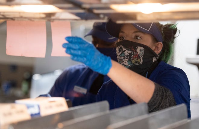 An employee checks an order in the kitchen at Culver's in Fort Collins, Colo. on Wednesday, Dec. 30, 2020. The state's hourly minimum wage rose again with the new year, part of a constitutional mandate to annually adjust the rate for inflation.
