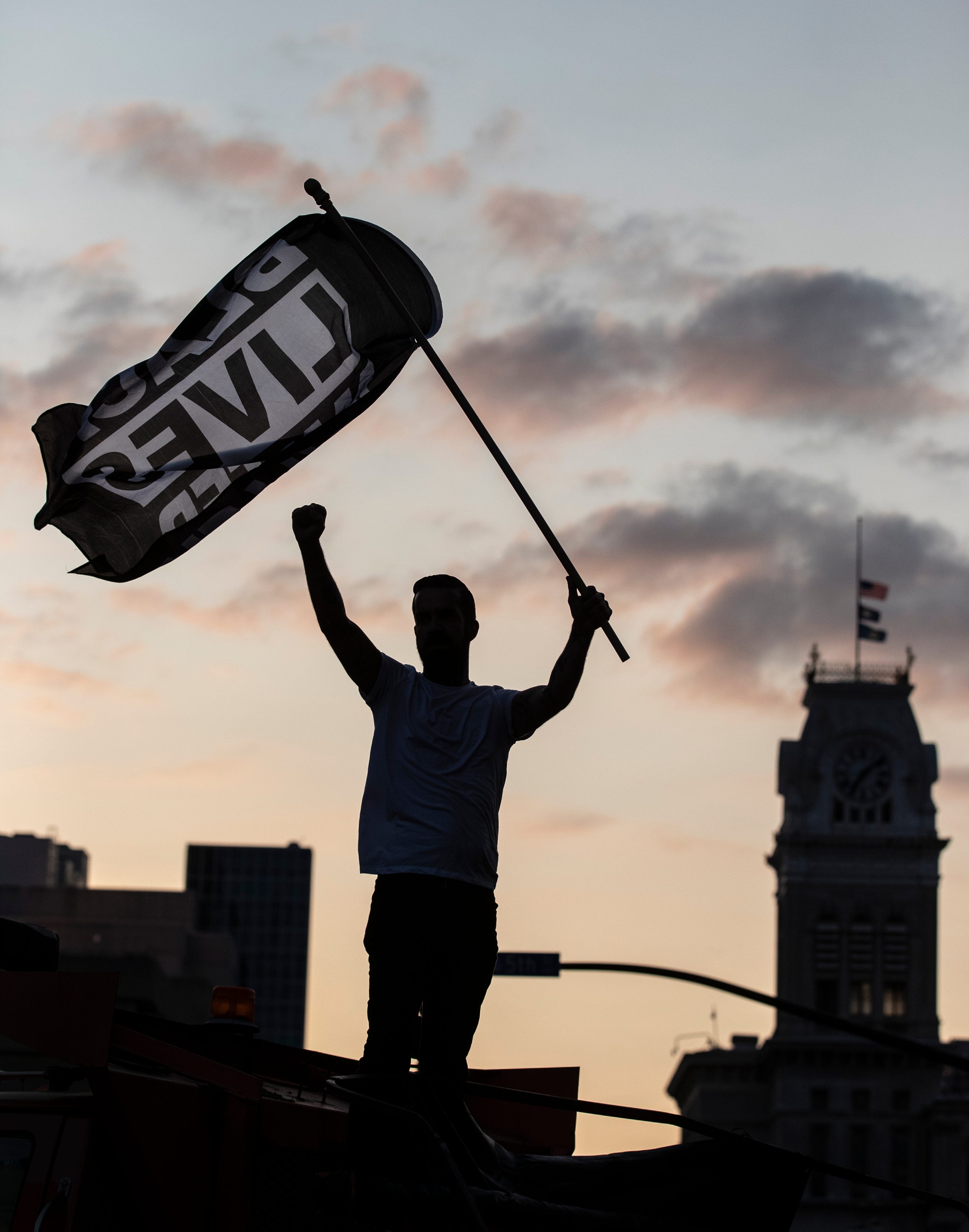 Dylan O'Donoghue stood atop a barricade at Fifth and Jefferson Streets in Louisville, Kentucky and waved a Black Lives Matter flag. Protesters marched through the streets for another night, demonstrating for justice for the late Breonna Taylor. Sept. 26, 2020.