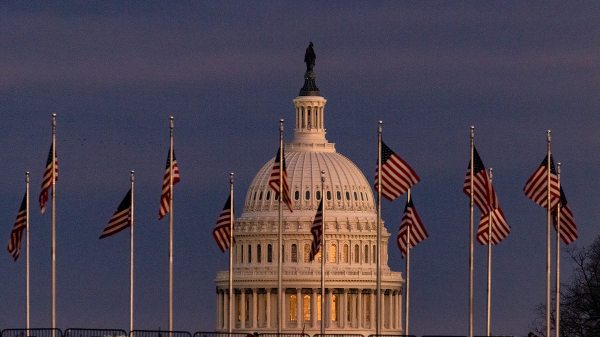 The U.S. Capitol Building is seen past the Washington Monument as the sun sets on December 26, 2020 in Washington, D.C.
