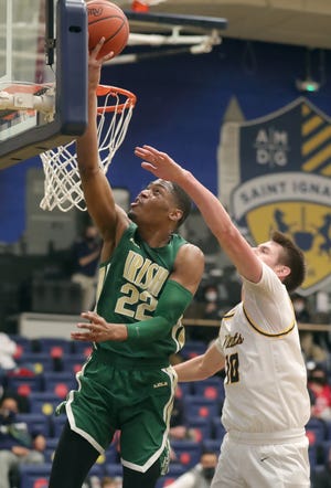 St. Vincent-St. Mary's Malaki Branham drives to the basket past St. Ignatius' Henry Raynor during the second quarter on Thursday, Dec. 31, 2020 in Cleveland, Ohio. The Irish won the game 50-40. [Phil Masturzo/ Beacon Journal]