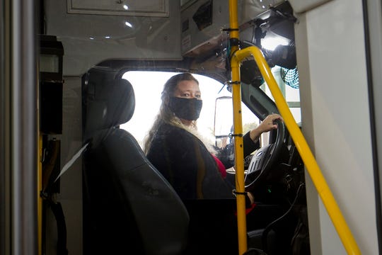 Benzie County bus driver Sandi Saxton wears some of the protective gear bus drivers are using to help prevent the spread of COVID-19 in Beulah, Wednesday, Dec. 23, 2020.