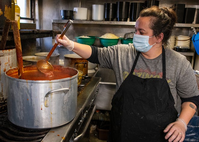Cook Darlene Keefe scoops up a serving of sauce in the kitchen at Il Camino Italian Restaurant in Leominster last week.