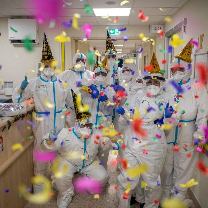 Healthcare workers in personal protective equipment (PPE) celebrate the new year in the Intensive Care Unit (ICU) on New Year's Eve in the COVID-19 department of the San Filippo Neri Hospital amid the coronavirus pandemic, on December 31, 2020, in Rome, Italy.
