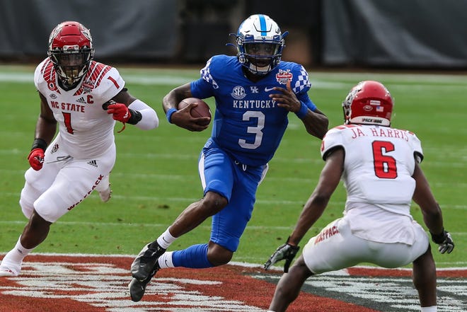 Kentucky Wildcats quarterback Terry Wilson (3) evades N.C. State tacklers during last year's TaxSlayer Gator Bowl. Kentucky won 23-21.