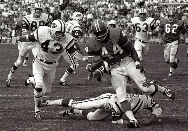 FILE - In this Sept.1969 file photo, Denver Broncos' Floyd Little avoids the tackle of New York Jets' Steve O'Neal (20) during a football game in Denver.  Little, the Hall of Fame running back who starred at Syracuse and for the Denver Broncos, has died.  The Pro Football Hall of Fame said he died Friday, Jan. 1, 2021.   (AP Photo/File)