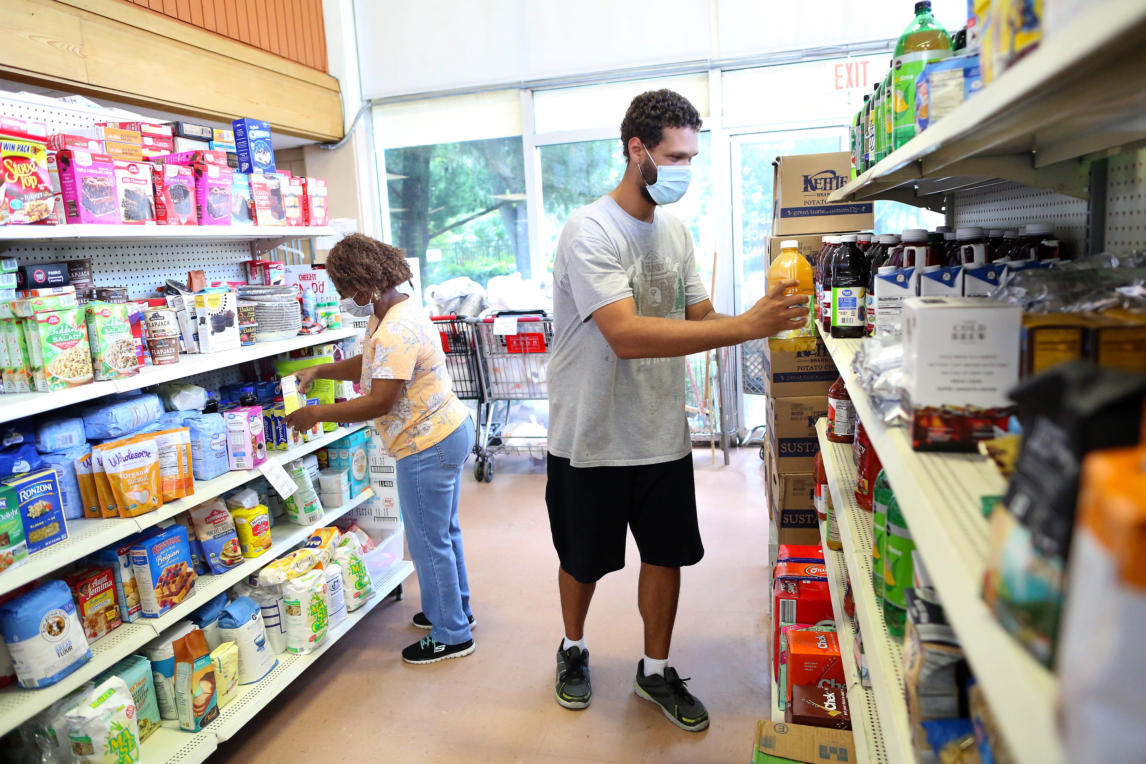 Volunteers organize food items on the shelves at the Bready of the Mighty food bank in Gainesville.