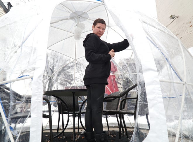                                On Jan. 5, 2021 Milford's Main Street Grill and Tavern manager Alisha Wallace steps inside one of the eatery's three outdoor igloos available to diners. The enclosed, heated tents, which can seat up to six diners, are available by reservation Wednesday through Saturdays.