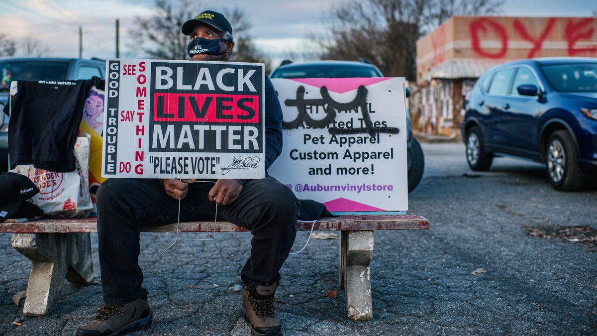 A Black Lives Matter supporter encourages people to vote Jan. 4 in Atlanta.