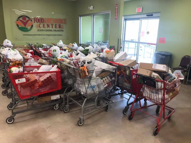Staff and volunteers at the Food and Resource Center ready shopping carts full of food to be distributed in March, when COVID-19 began spreading into southern Oklahoma.